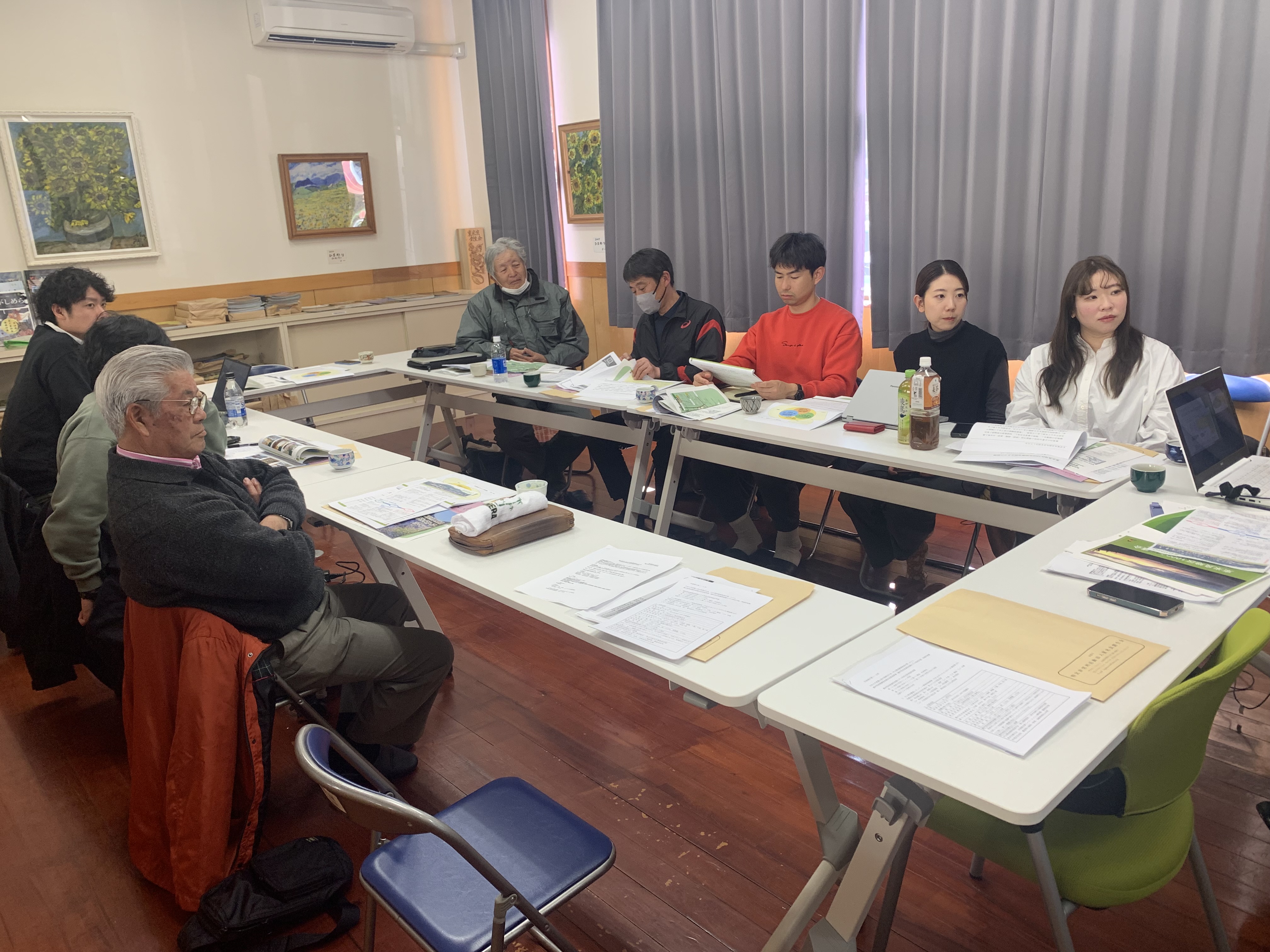 会議室全景・コの字型テーブルに多数の参加者