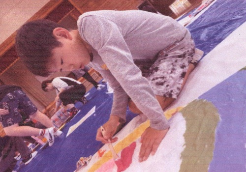 こいのぼりにペンキで絵を描く児童