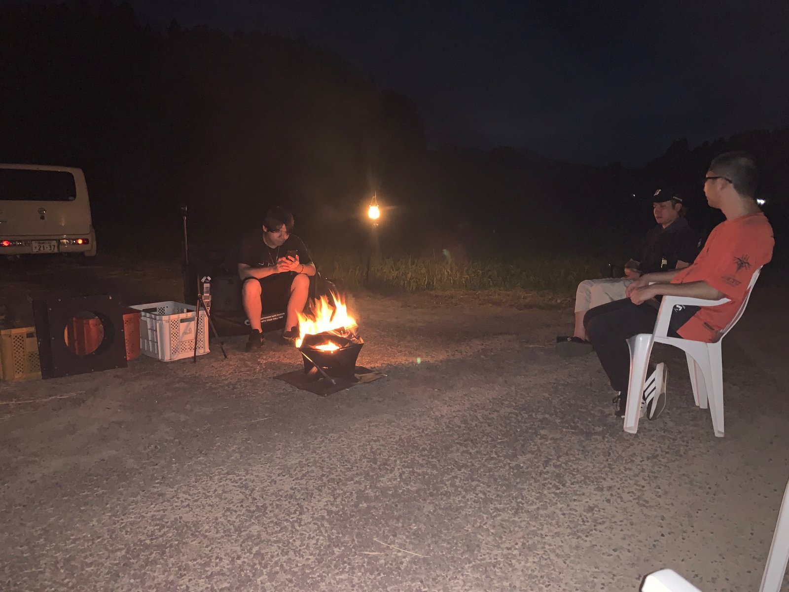 夜の焚き火を囲む参加者たち
